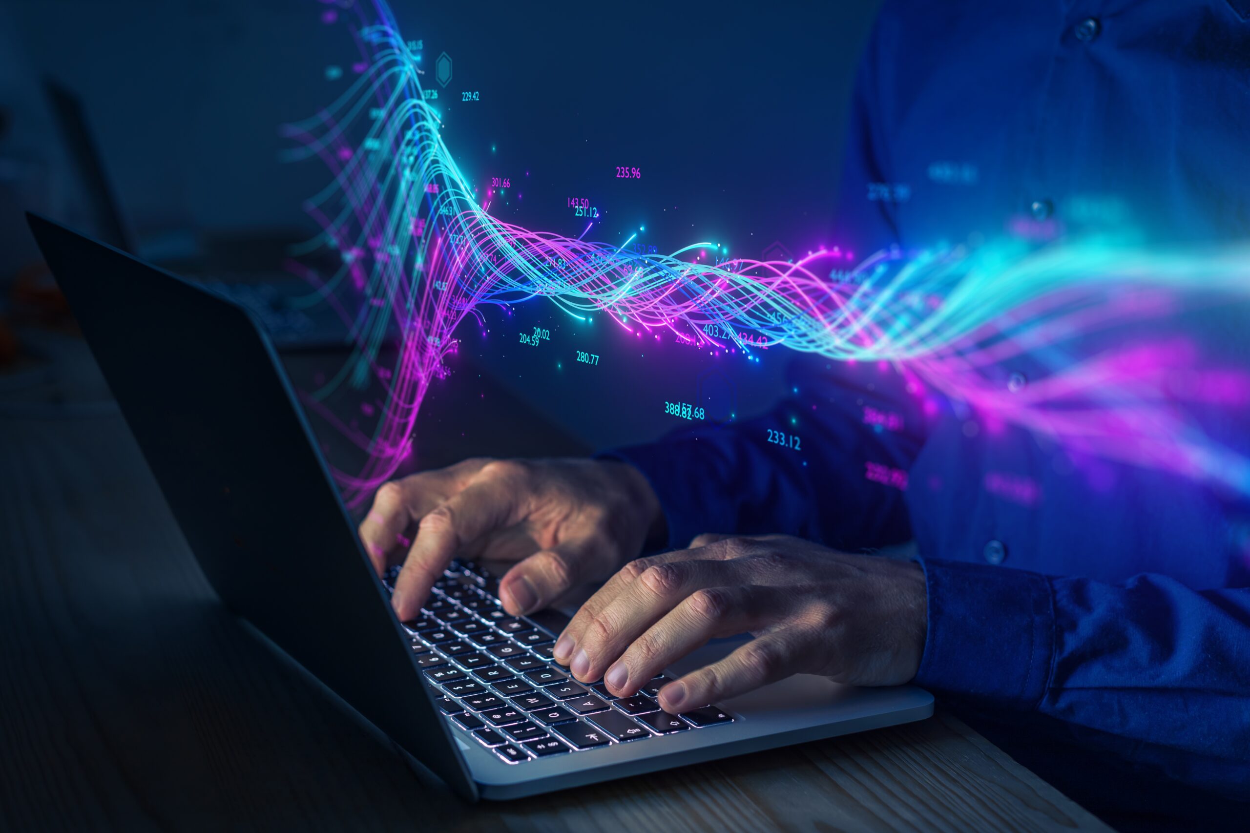 Image of hands typing on a laptop, surrounded by data.